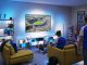 Suasana nobar pertandingan sepak bola di ruang keluarga menggunakan Philips Smart Lighting Connected by WiZ yang menyinkronkan efek cahaya biru di sekitar TV untuk menciptakan pengalaman menonton yang lebih imersif.