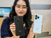 Dua varian HONOR X5c Plus ocean cyan dan black dipegang oleh seorang model