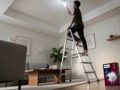 Seorang pemuda memasang bohlam Philips Ultra Bright di plafon rumah