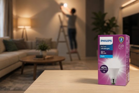 Ketika Rumah Jadi Pusat Kehidupan, Pencahayaan Jadi Penentu Kualitasnya Kotak kemasan lampu philips UltraBright dengan latar belakang orang sedang memasang lampu