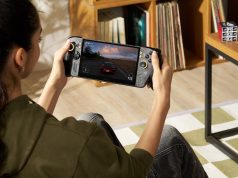 Seorang gamer memainkan ROG XBOX Ally X20, handheld gaming PC edisi 20 tahun ROG, sambil menikmati game balap dengan desain perangkat hitam beraksen emas.