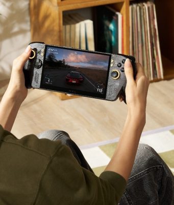 Seorang gamer memainkan ROG XBOX Ally X20, handheld gaming PC edisi 20 tahun ROG, sambil menikmati game balap dengan desain perangkat hitam beraksen emas.