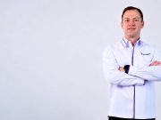 Thomas Hundt Komisaris XLSMART berdiri dengans rsagam xlsmart sambil bersedekap